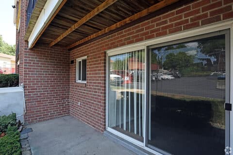 Covered brick patio with sliding glass doors at a ground-floor Canal House apartment